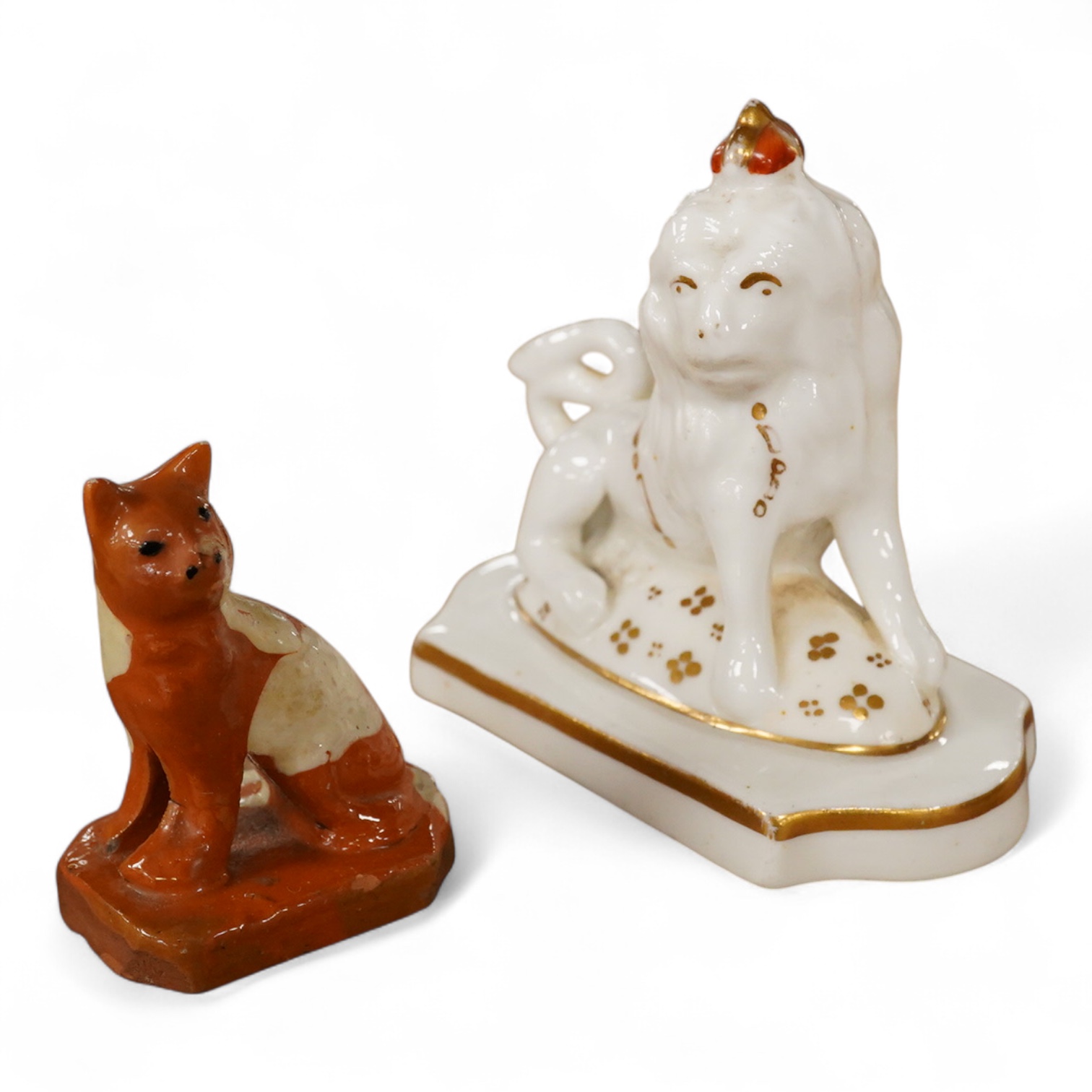 A Staffordshire lion with crown, c.1830-50 and a Staffordshire slipware cat, largest 8.5cm high (2)